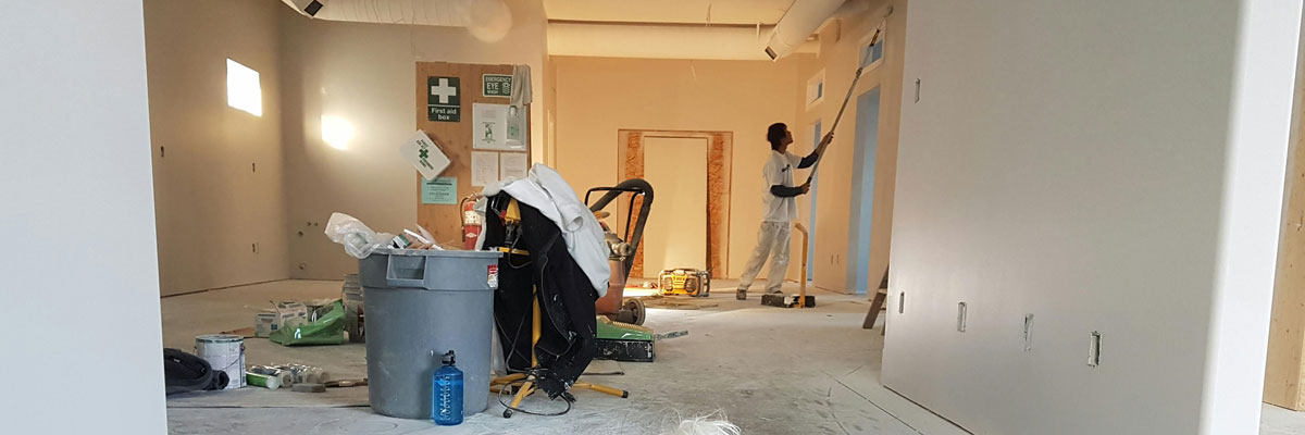 a man painting inside a new commercial building