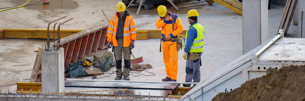 three men at work on a large construction project